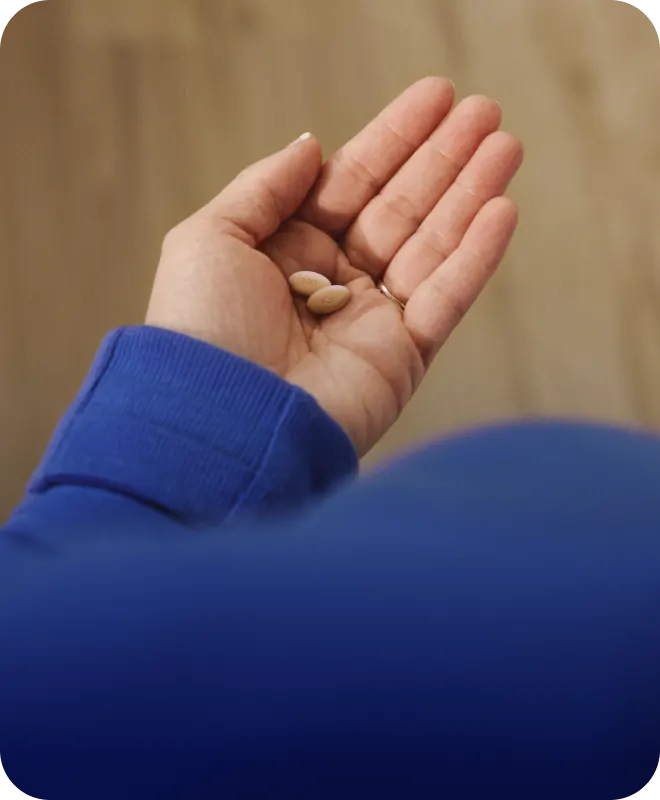 Hand holding EKTERLY® (sebetralstat) tablets