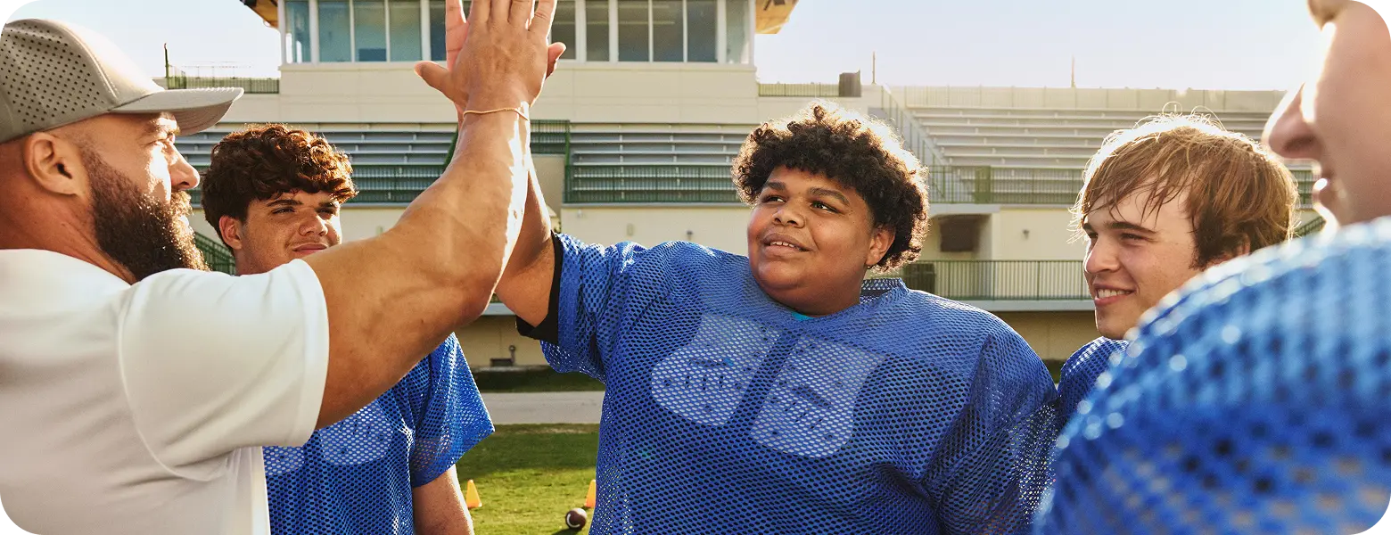 Real EKTERLY® (sebetralstat) patient Ellis high-fiving football coach