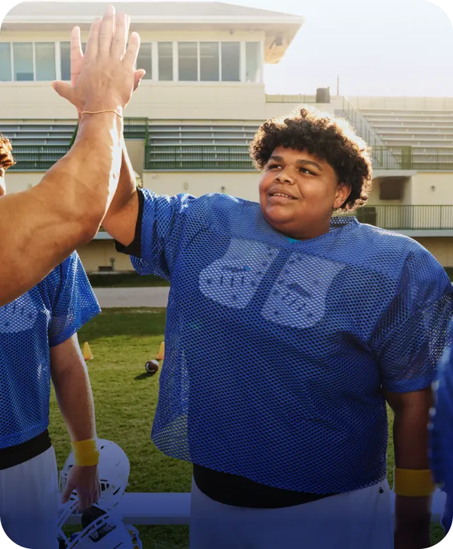 Real EKTERLY® (sebetralstat) patient Ellis high-fiving football coach