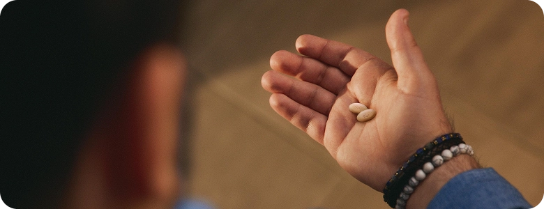 Hand holding EKTERLY® (sebetralstat) tablets